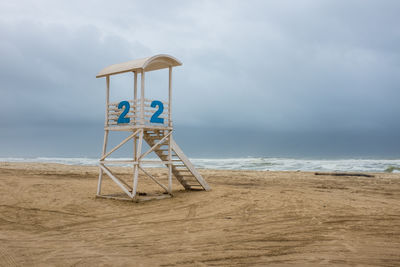 Lifeguard hut on beach against sky