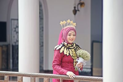 Portrait of woman standing against wall