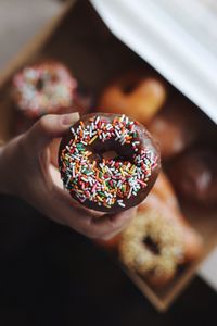 Cropped image of woman holding donut