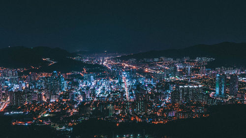 Illuminated cityscape against sky at night