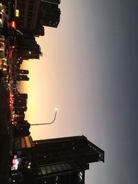 Illuminated cityscape against sky during sunset