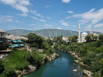 River amidst buildings in city against sky