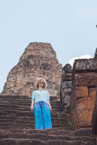 Woman standing at historical building against clear sky