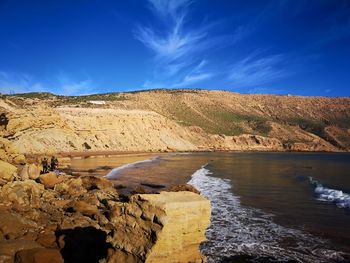 Scenic view of land against blue sky