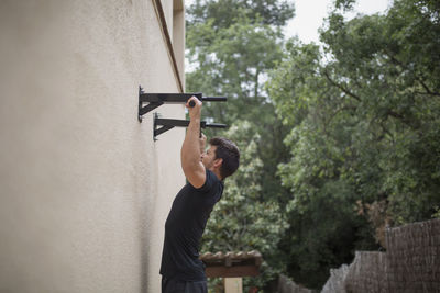 Side view of man skateboarding on wall