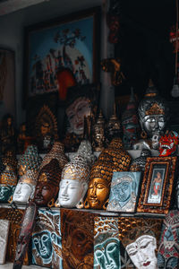 Golden silver handmade gold plated buddha face masks on a counter in a street shop