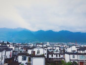 View of cityscape against cloudy sky