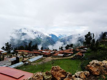 High angle view of houses by trees against sky