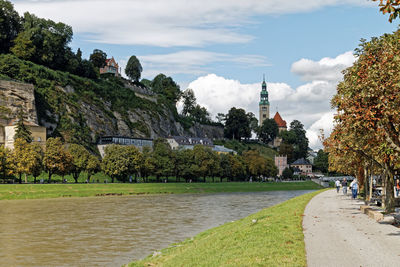 View of river and buildings against cloudy sky