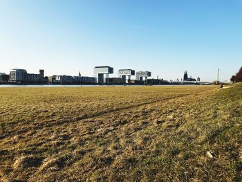 Distance view of city by river against clear sky