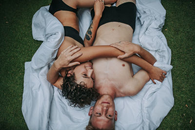 High angle view of couple relaxing on bed