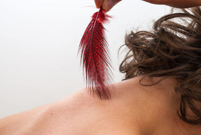 Midsection of woman with red hair against white background