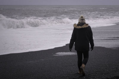 Rear view of woman standing on beach