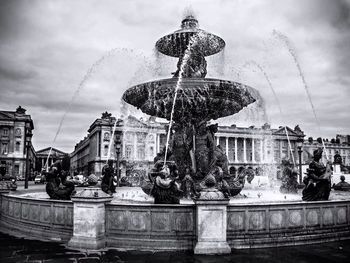 Low angle view of fountain against cloudy sky