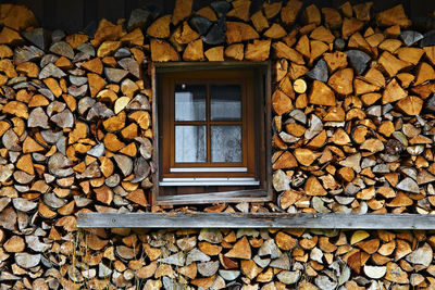 Window amidst stacked logs