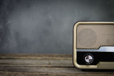 Close-up of old radio on table against wall