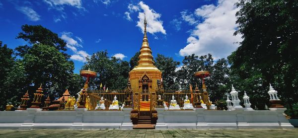 Temple against building and trees against sky