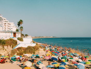 People on beach against clear sky