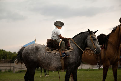 Portrait of argentinian boy horseback riding