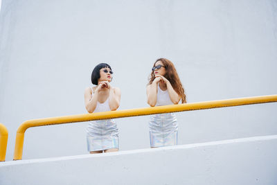 Lesbian couple standing by railing outdoors