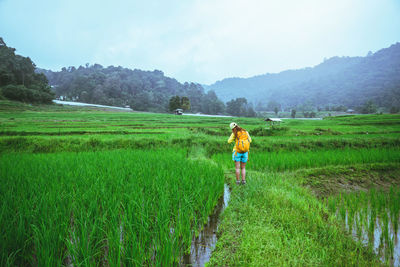 Full length of woman standing on field against sky