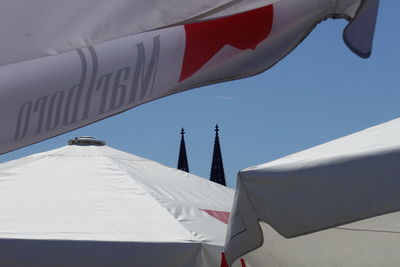 Low angle view of flags hanging on building against sky