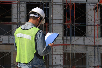 Rear view of men working at construction site