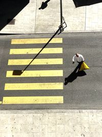 High angle view of man walking on zebra crossing