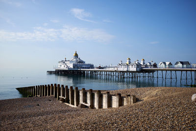 Eastbourne seafront and pier, east sussex, england. a low angle view across the pebbles on the beach