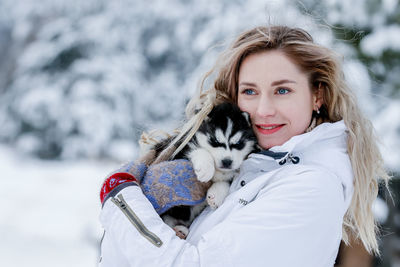Beautiful young woman with dog outdoors during winter