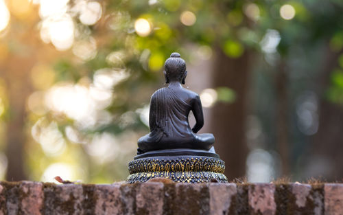 Buddha statue against stone wall