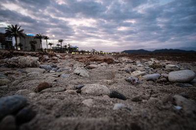 Surface level of beach against sky during sunset