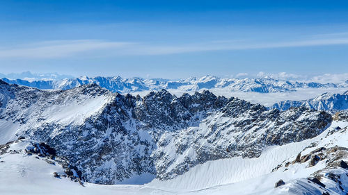 Scenic view of snowcapped mountains against blue sky