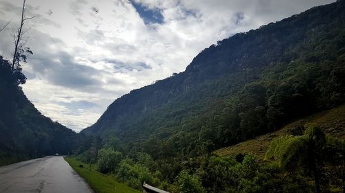 Country road against cloudy sky