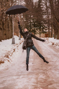 Full length of man skateboarding on snow during winter