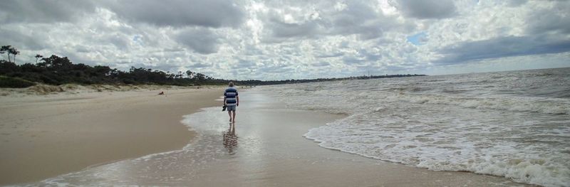 Scenic view of beach against cloudy sky