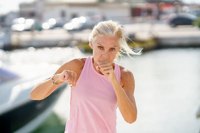 Determined woman doing kick boxing at beach