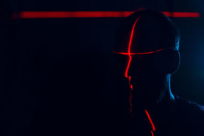 Laser light falling on man in darkroom