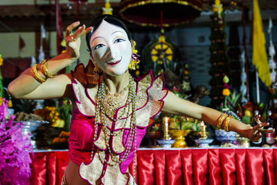 Woman in mask dancing during traditional festival