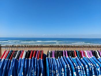 Multi colored umbrellas hanging on beach against clear blue sky