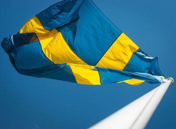 Low angle view of swedish flag waving against clear sky