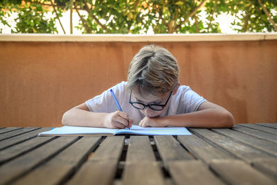 Portrait of boy with book on table