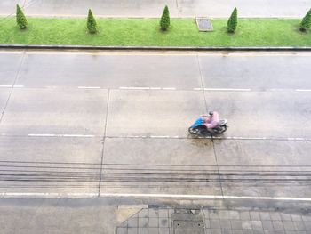 High angle view of man riding motorcycle on wet road