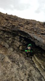 Portrait of boy crouching in cave