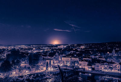 High angle view of illuminated cityscape against sky at night