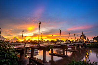 Bridge over river against sky during sunset
