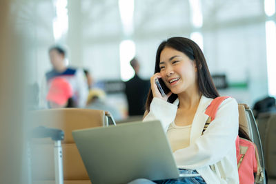 Young woman using laptop at cafe