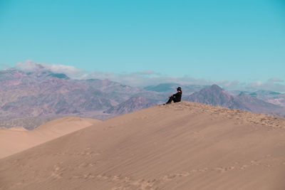 Rear view of man walking on desert