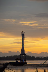 Ship in water against sky during sunset