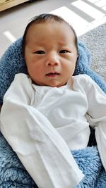 Portrait of cute baby relaxing on bed at home